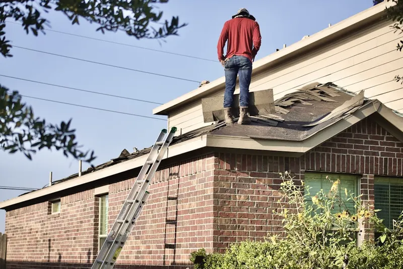 Professional roofer working on a residential roof in White House